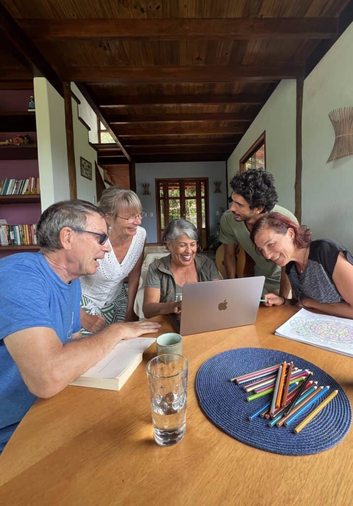 Group of diverse people collaborating around a laptop at a community gathering.