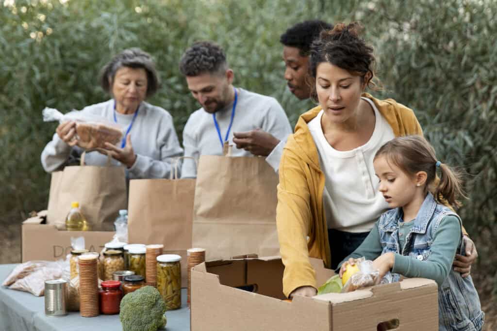 People sharing food and supplies at a community gathering.