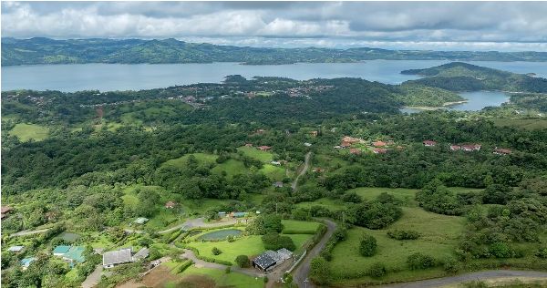 Scenic aerial view of lush green landscape near a large lake.