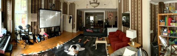 Spacious living room with large TV, red sofa, and musical instruments.