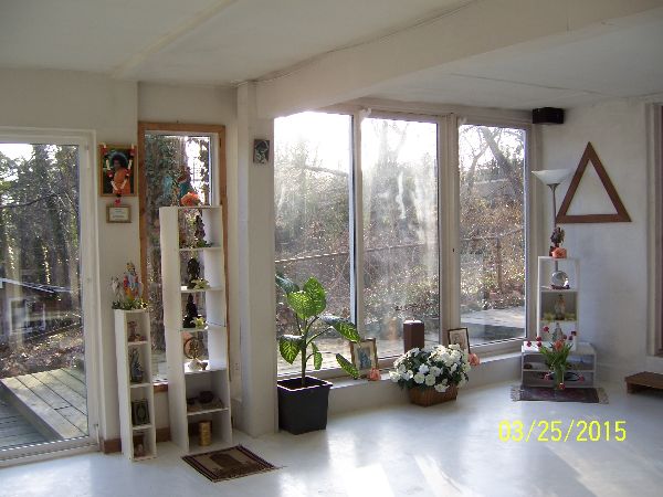 Bright interior with large windows, plants, and decorative shelves at Foundation for Intentional Co.