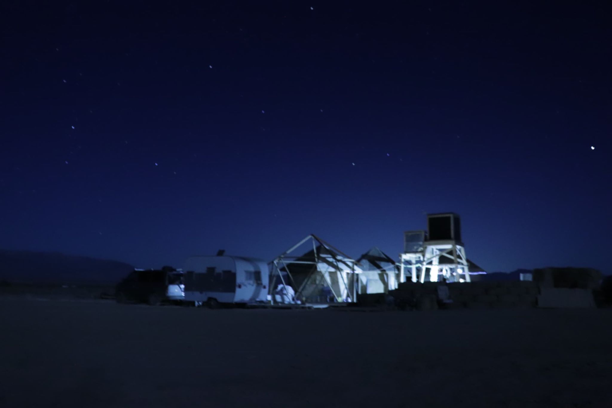 Night view of the Foundation for Intentional Community's outdoor setup under stars.