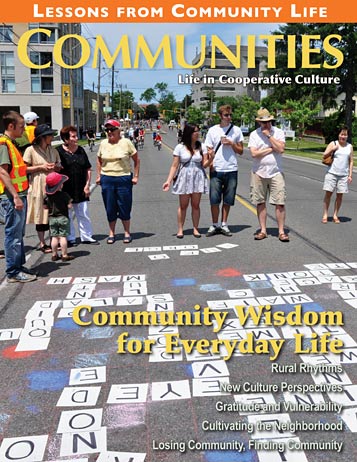 Group of diverse people walking and playing on a street with large alphabet blocks.