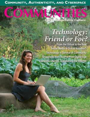 Woman sitting outdoors with a laptop in a lush green setting.