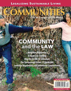 Two people reaching out and holding hands in front of a large tree.