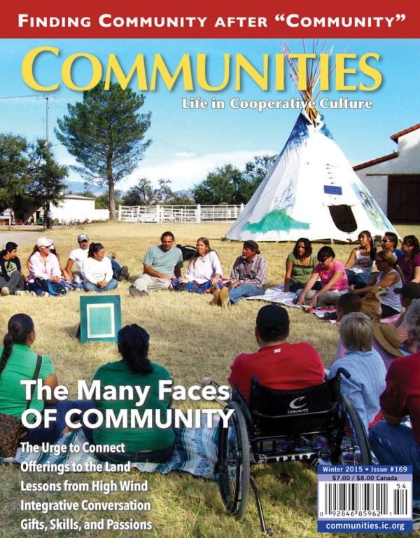 Community gathering outdoors with diverse group sitting in a circle near a teepee.