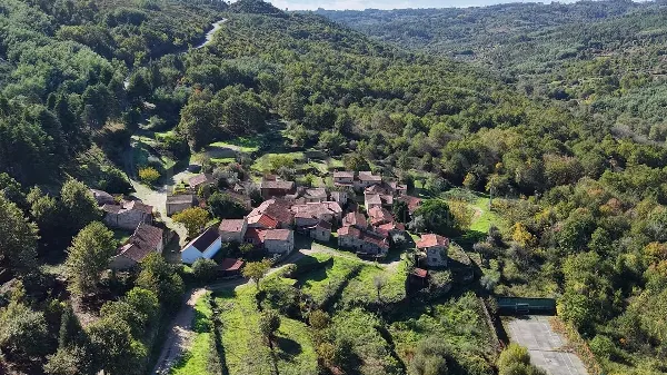 Aerial view of a rural community in Central Portugal surrounded by lush green hills.