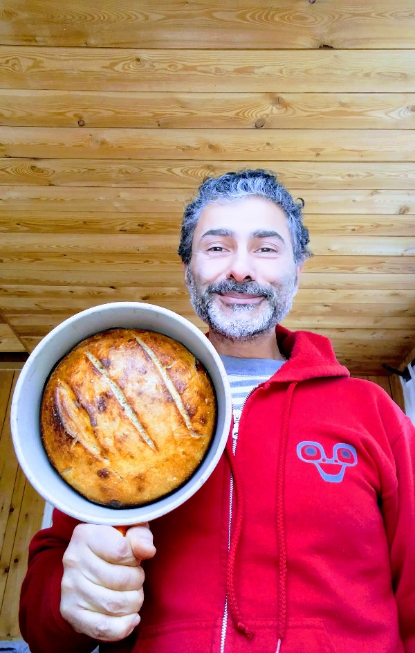 Man holding freshly baked pie in a cozy wooden kitchen setting.