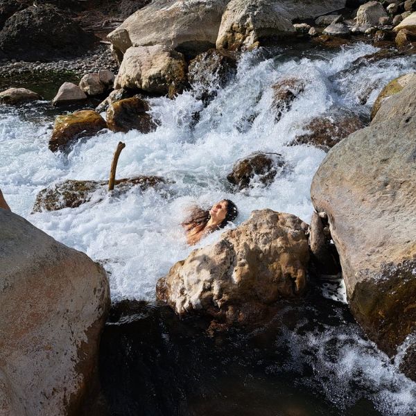 Person swimming in a rocky river at Edenhope Nature Preserve.