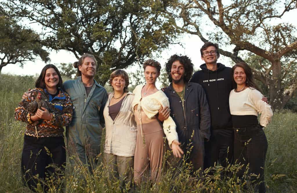 Diverse group of people smiling outdoors in a natural setting.