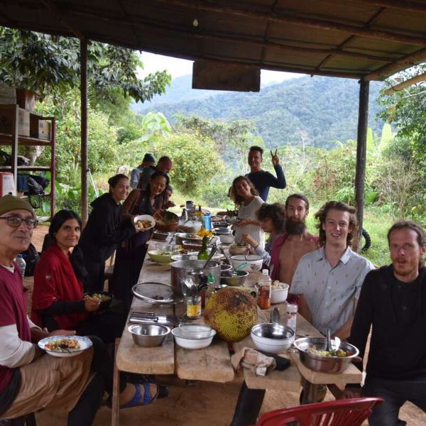 Group of people enjoying a meal outdoors at Foundation for Intentional Community.