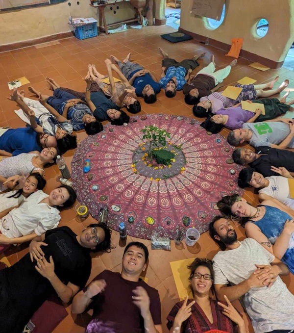 Group of people lying in a circle on the floor during a community gathering.