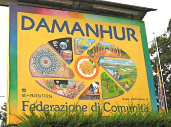 Damanhur community sign with colorful artwork and logo in Italy.