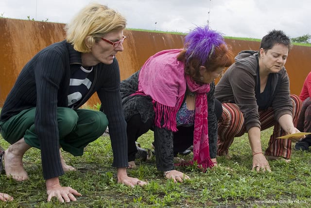 Group of diverse women planting seedlings outdoors for environmental sustainability.