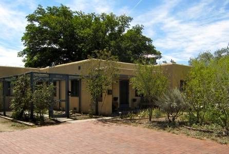 Modern community building with desert landscaping and trees in Albuquerque.