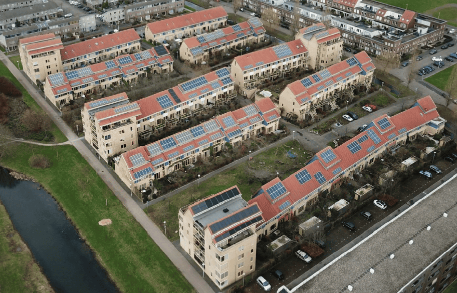 Aerial view of Dutch cohousing community with solar panels on roofs.