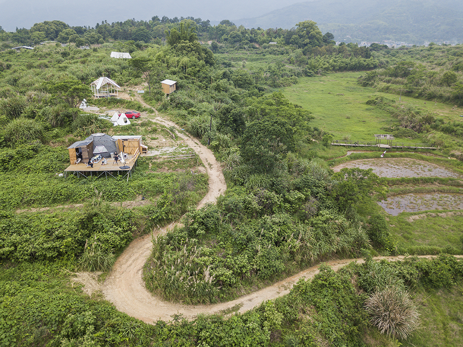 Aerial view of a rural community with houses, greenery, and dirt paths in Southern Life.