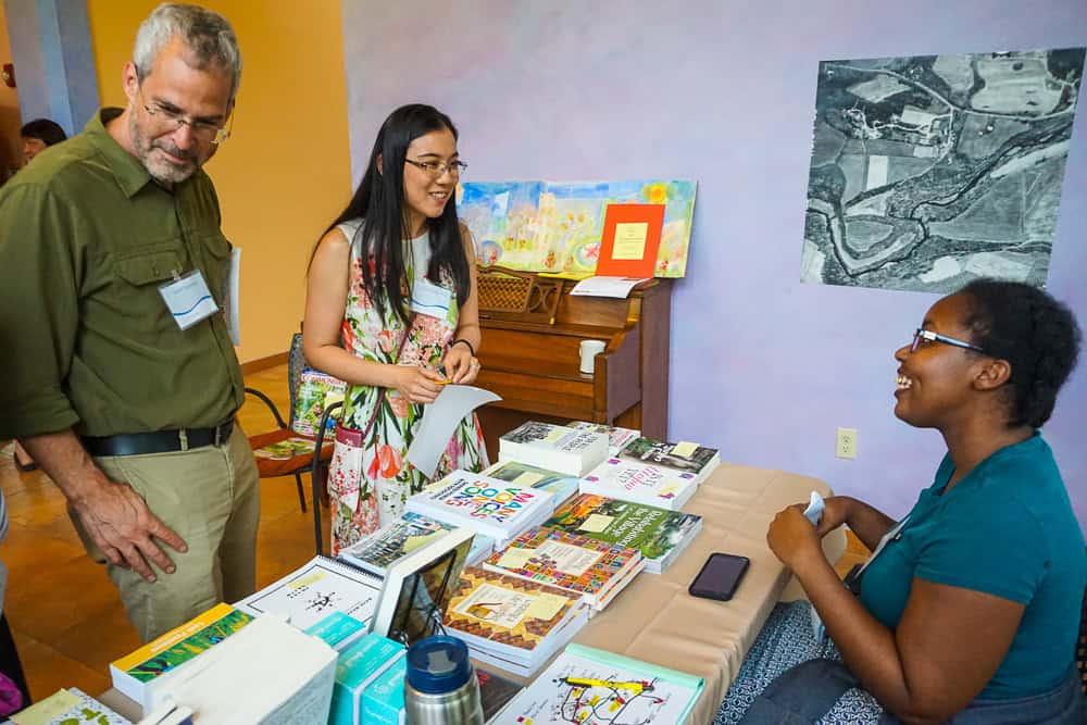 Diverse group at book table promoting intentional community principles.