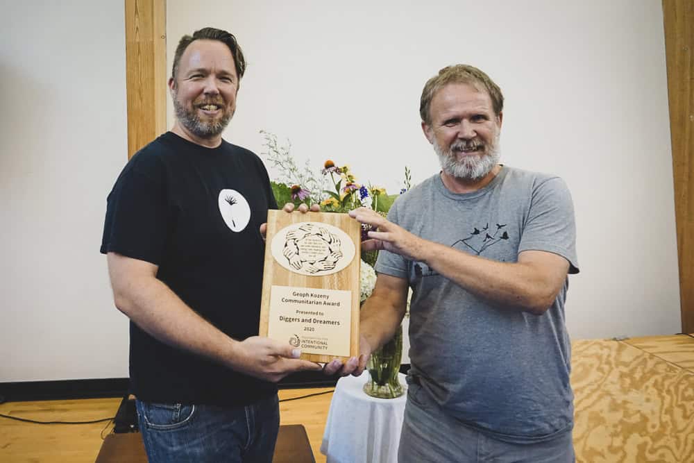 Two men holding an award at the Foundation for Intentional Community event.