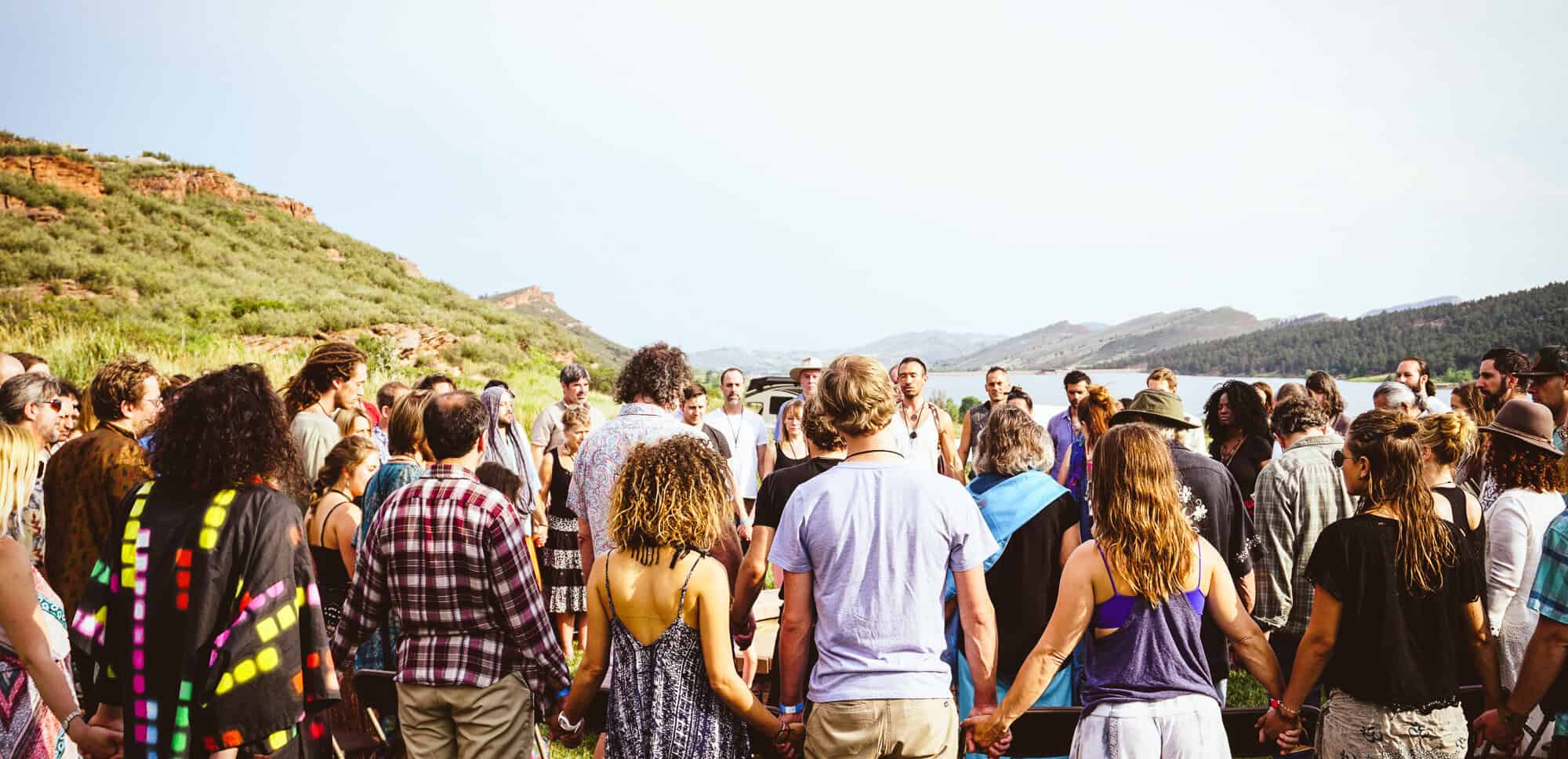 People gathered outdoors near a lake for a community event or gathering.