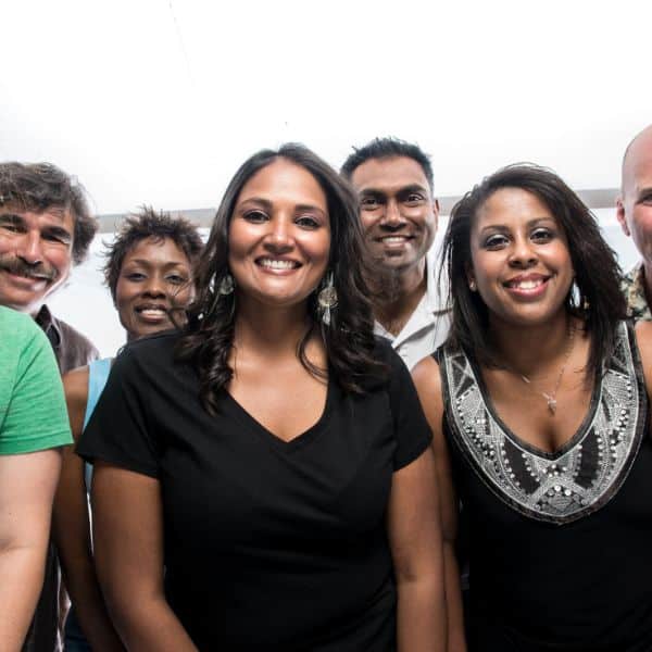 Diverse group of smiling people outdoors for community diversity awareness.