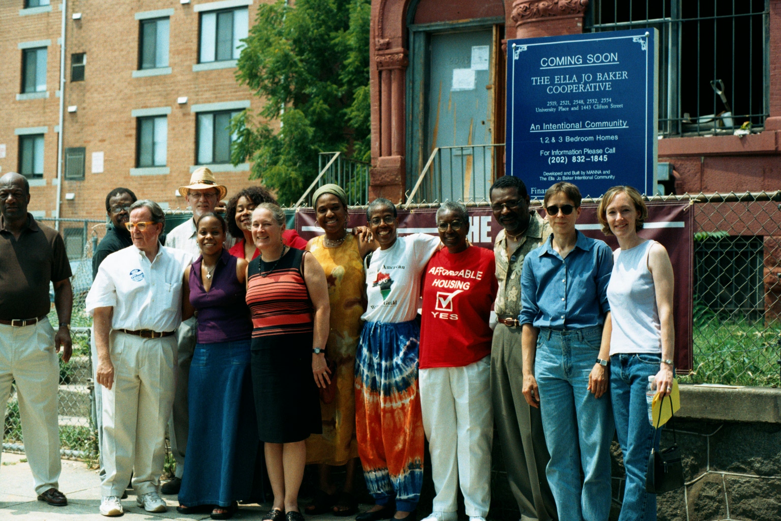 Group of diverse people standing outside Ella Jo Baker Cooperative building.