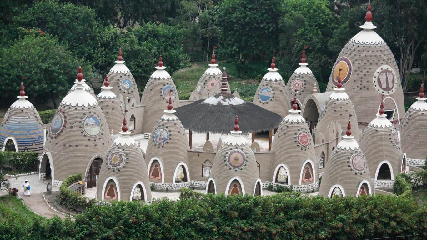 Unique cone-shaped structures of an eco-community in Peru surrounded by greenery.