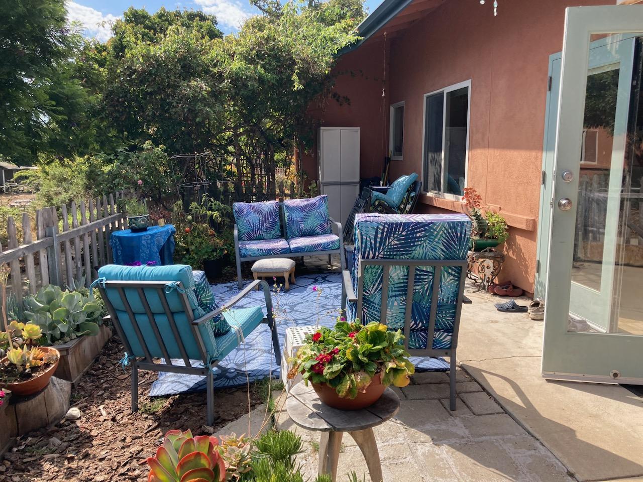 Cozy outdoor patio with colorful chairs and potted plants in California cohousing.