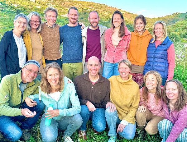 Group of diverse people outdoors in a lush green landscape for intentional community.