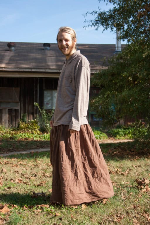 Person in gender-bending attire standing outdoors on a sunny day.