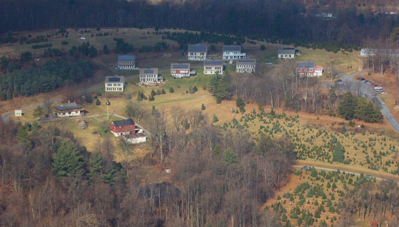 Aerial view of The Hundredfold Farm Community with houses and farmland.