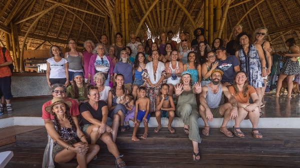 Group of diverse people gathered in a bamboo structure at Alegría Village.