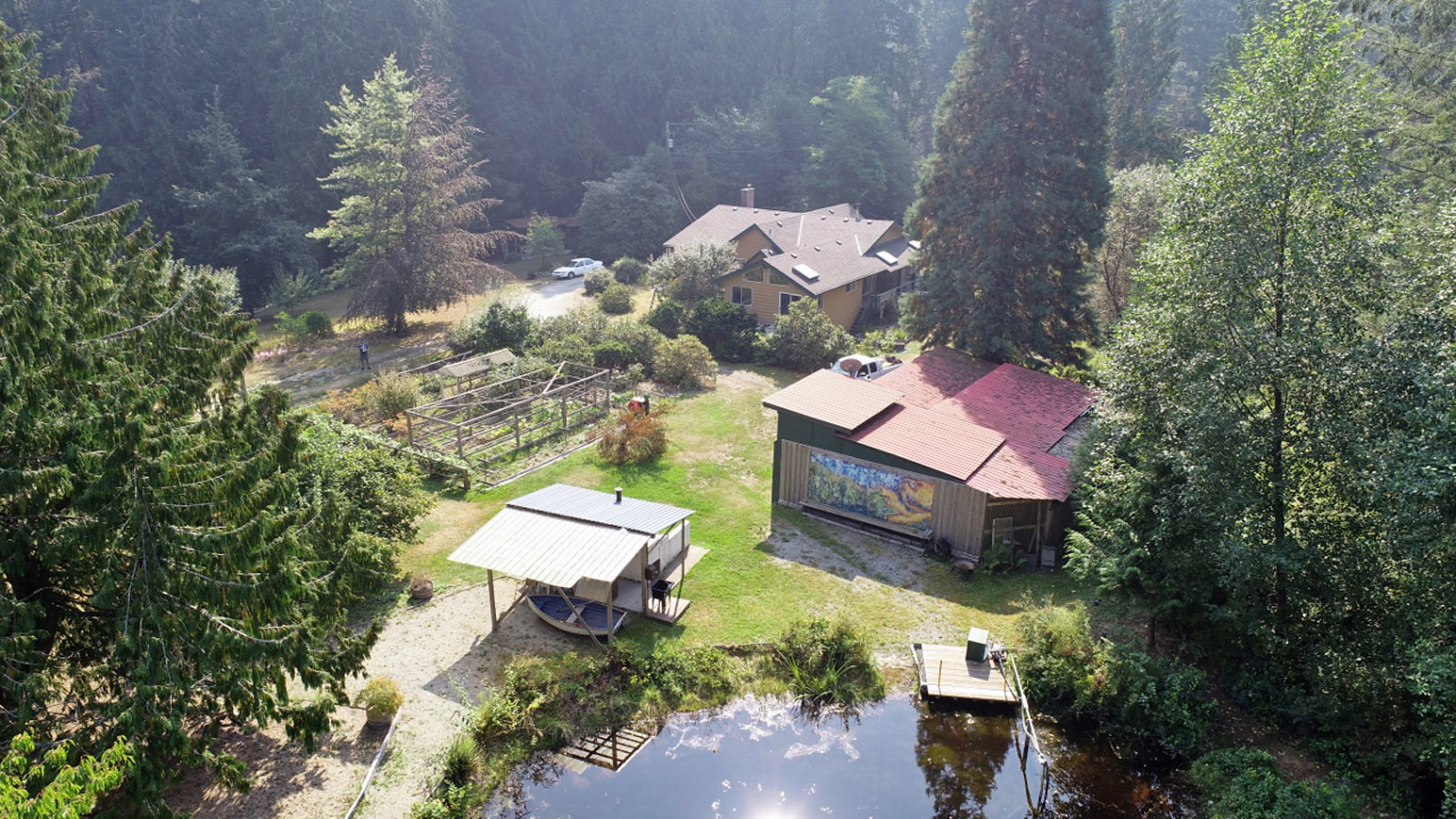 Aerial view of Hearthstone Village Cooperative with houses, pond, and lush greenery.