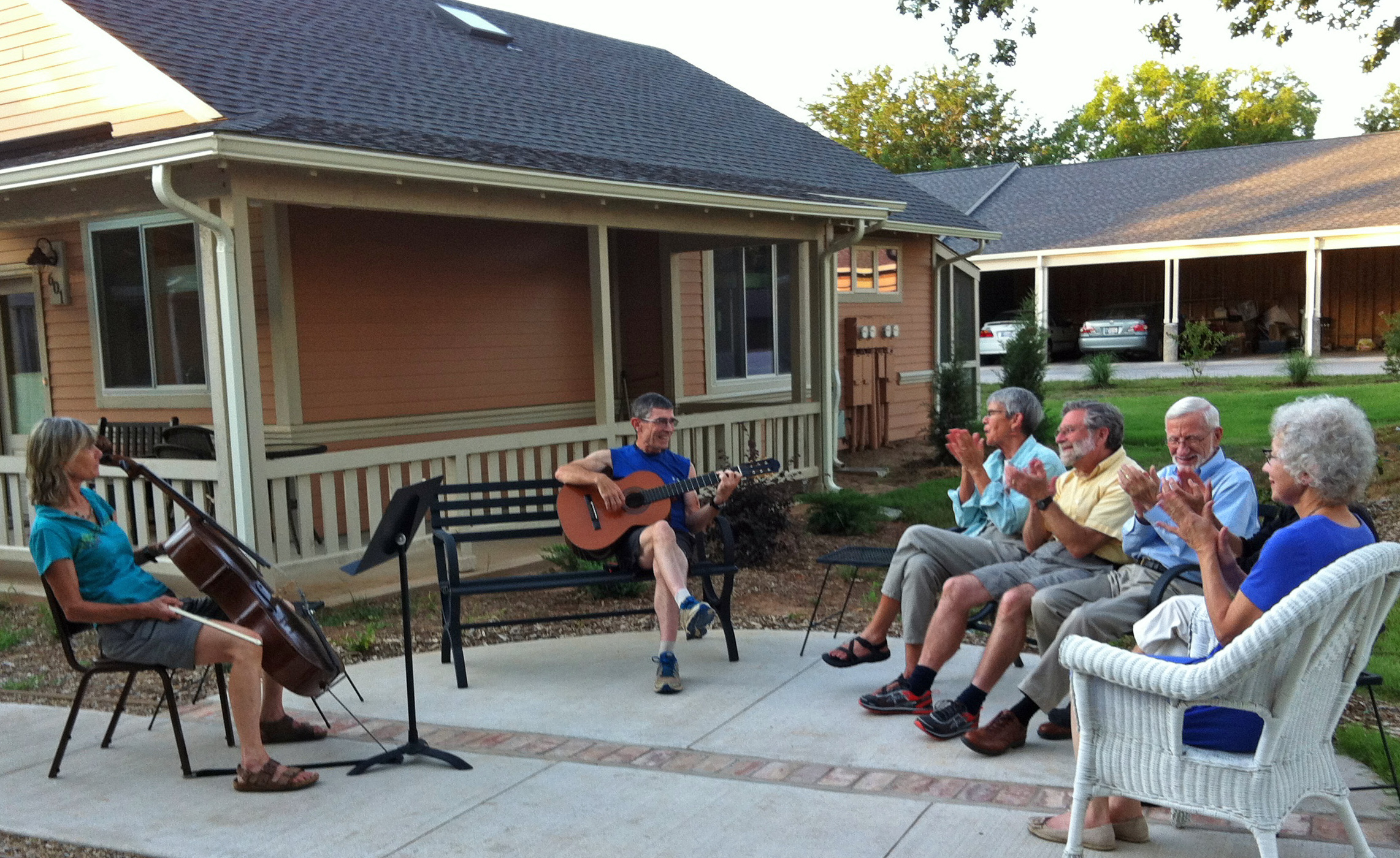 Community gathering with live music and singing outdoors at Oakcreek Community.