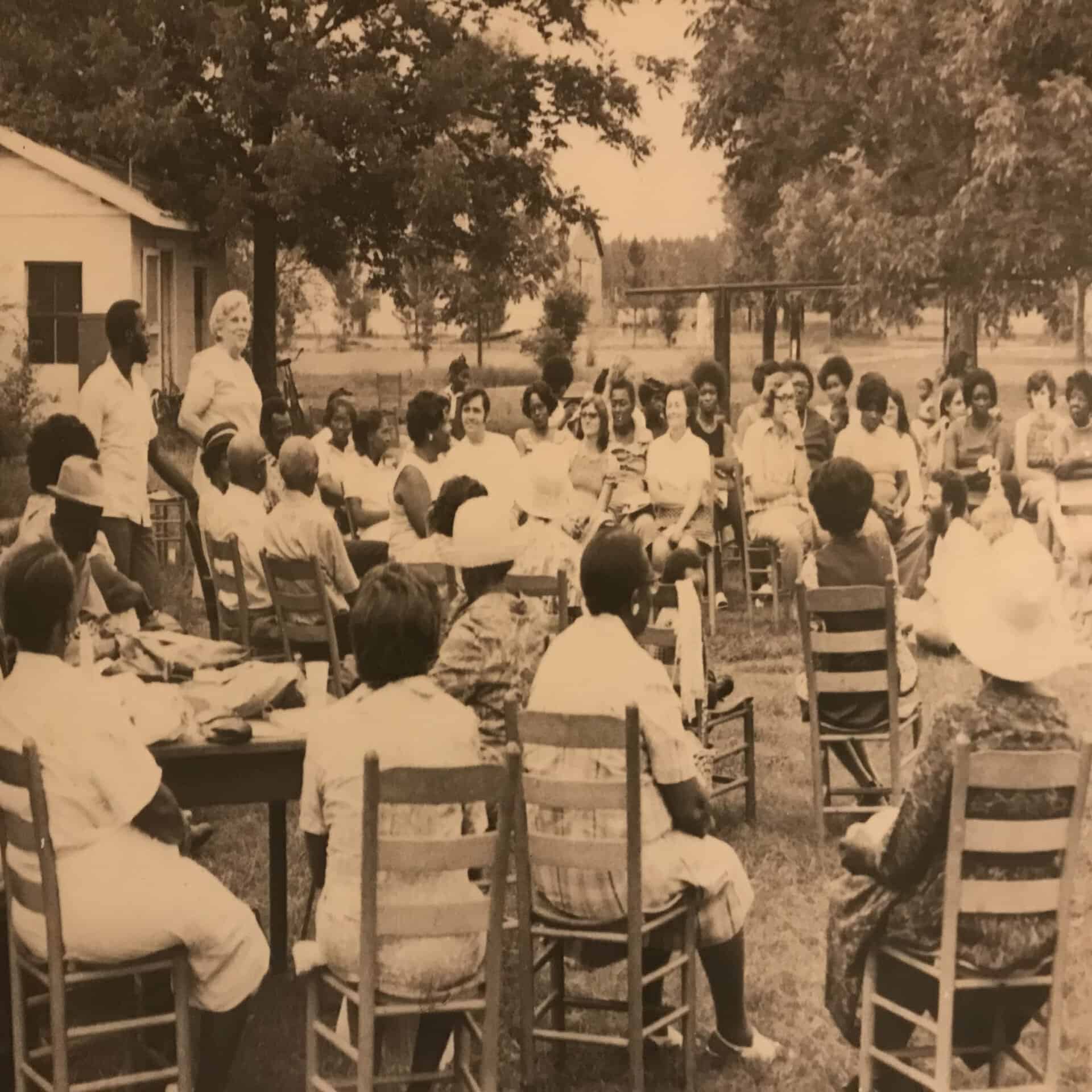 Group of people gathered outdoors at a community event or meeting.