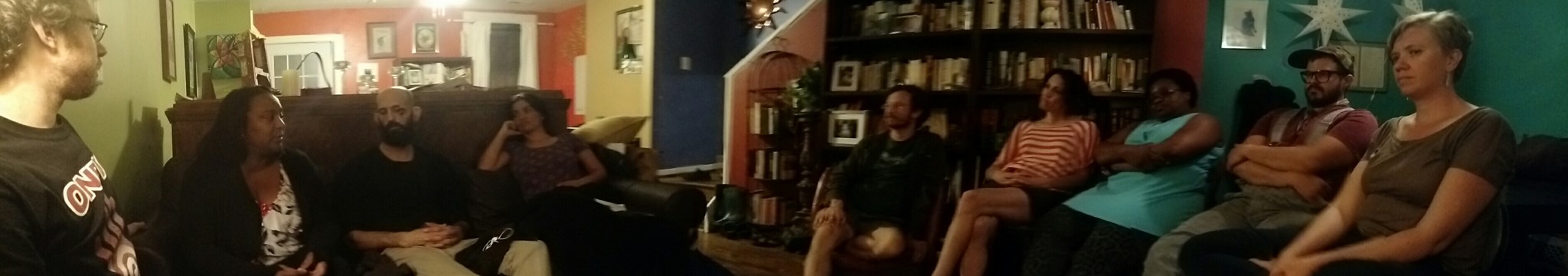 Group of people attending a community meeting in a cozy indoor setting.