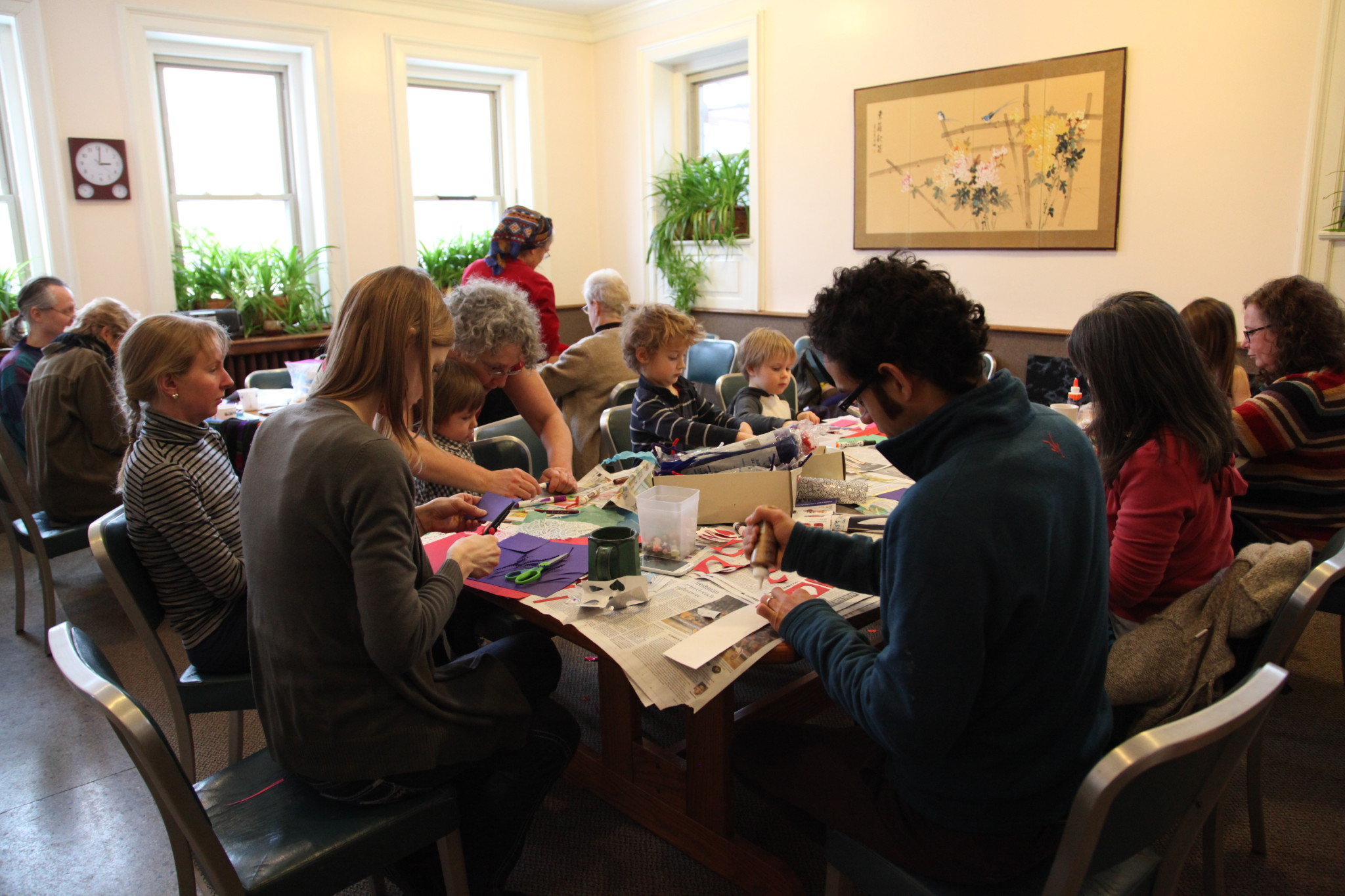 Community members engaging in a group activity at a table in a cozy room.