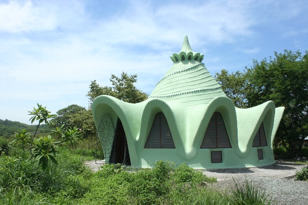 Unique green eco-friendly building with organic shapes and pointed roof.
