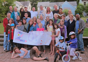 Group of diverse people at intentional community event with children and bikes.