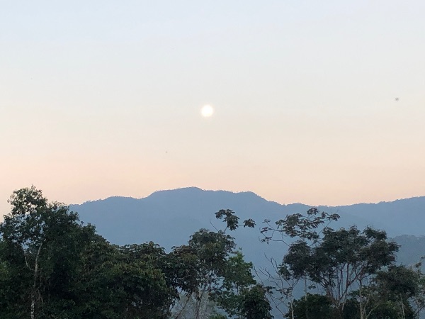 Scenic view of mountains, trees, and a setting sun in Ecuador.