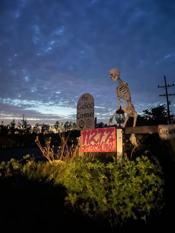 Decorative skeleton and signs at The Cuckoo Compound during dusk.