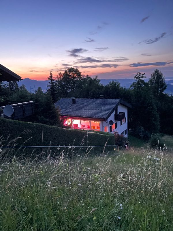Cozy house in a scenic mountain landscape at sunset in Vorarlberg, Austria.