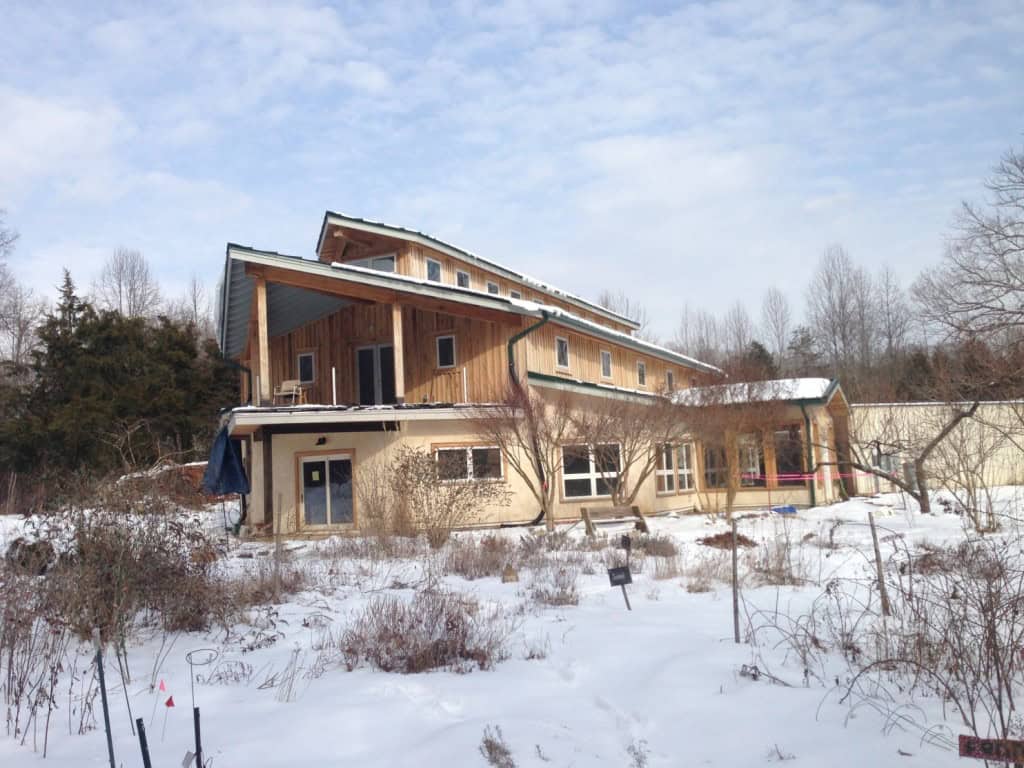 Modern eco-friendly building with sloped roof in snowy landscape.