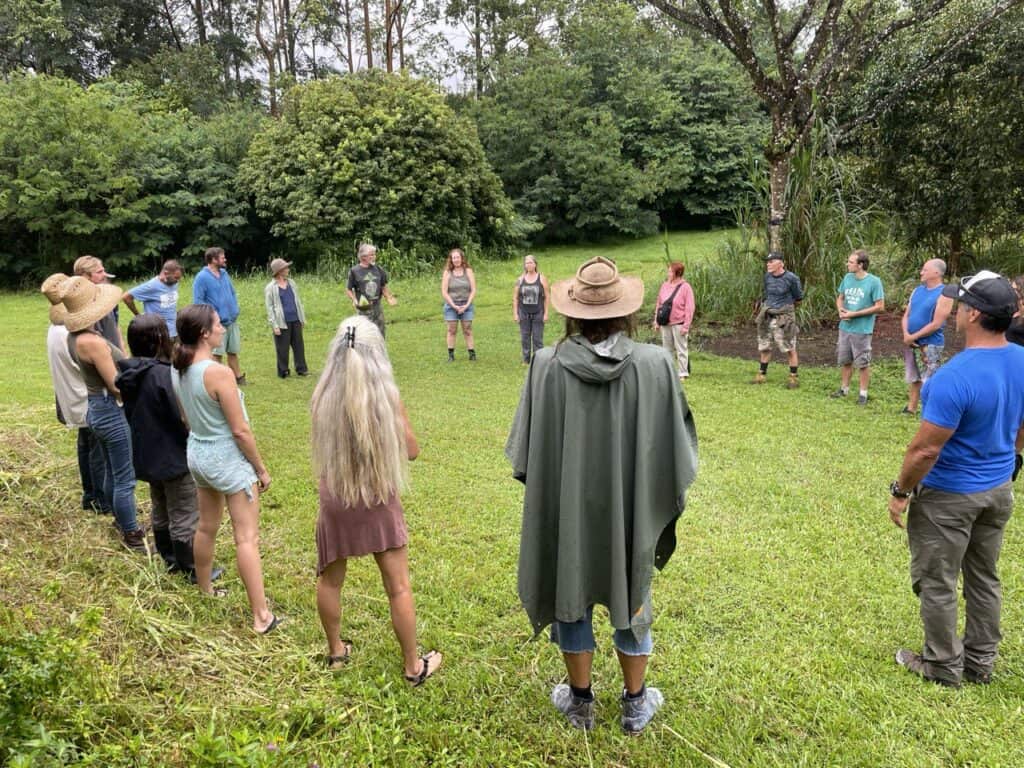 Group of people standing in a circle outdoors at Foundation for Intentional Community event.