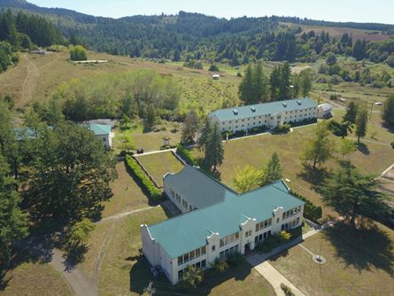 Aerial view of a large rural property with multiple buildings and green fields near Portland.