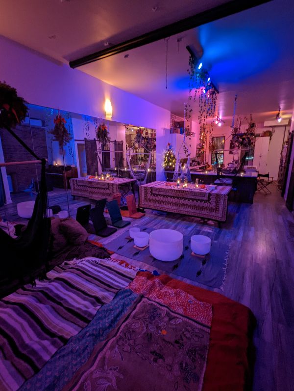 Vibrant indoor space with colorful lighting, plants, and cozy seating arrangements.
