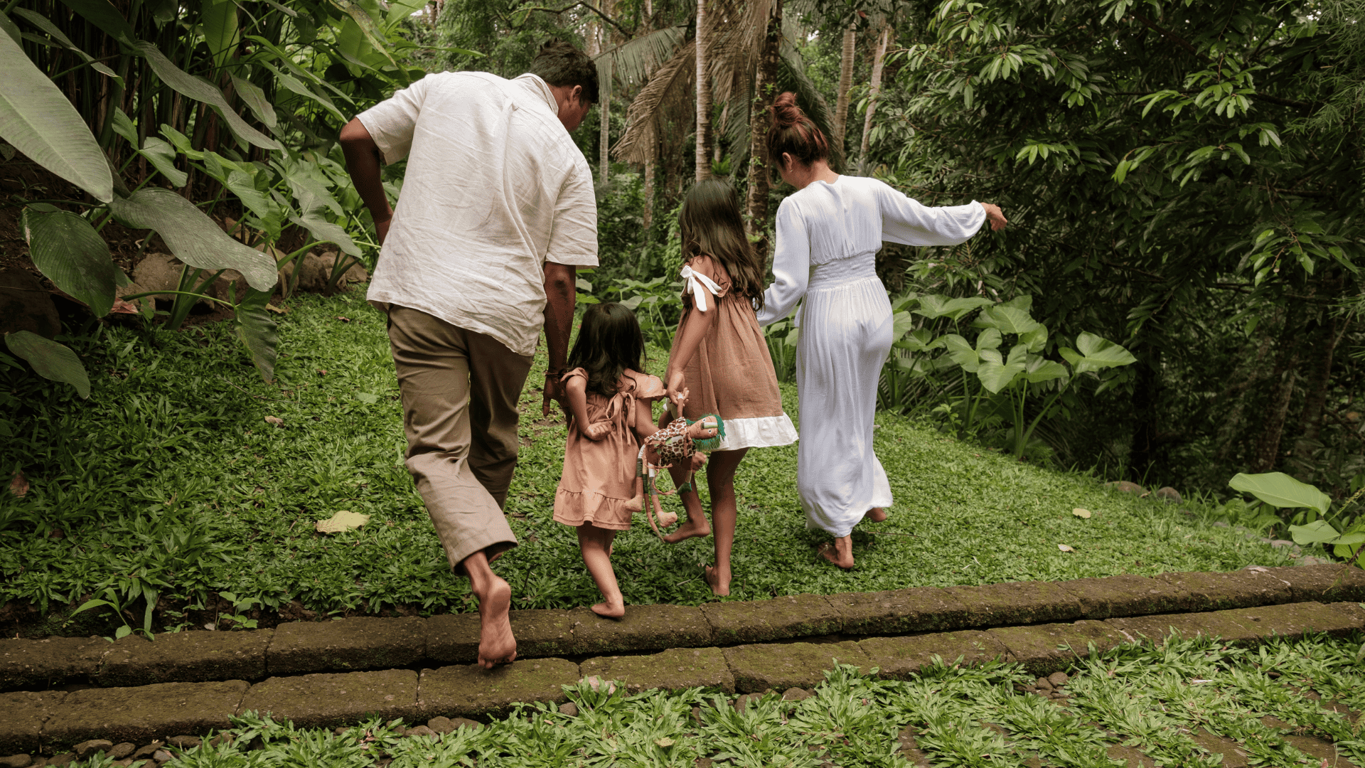 Family walking together in lush green community garden for intentional living.