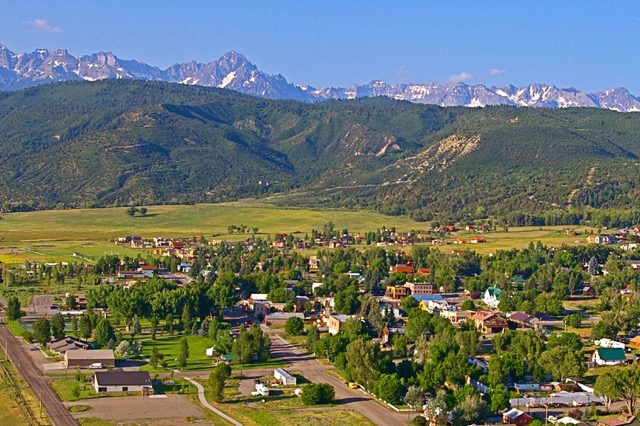 Scenic view of a community with mountains in the background and lush greenery.