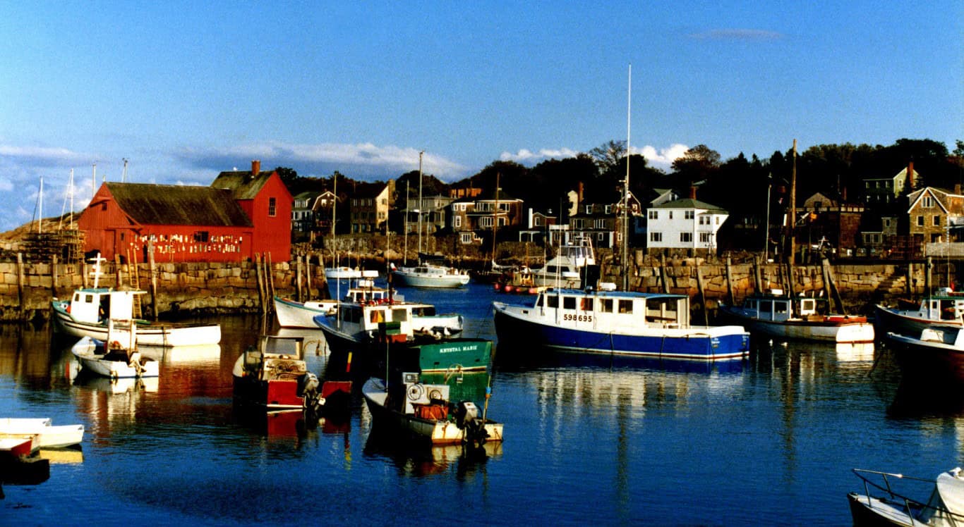 Harbor with boats and colorful houses in a coastal community.