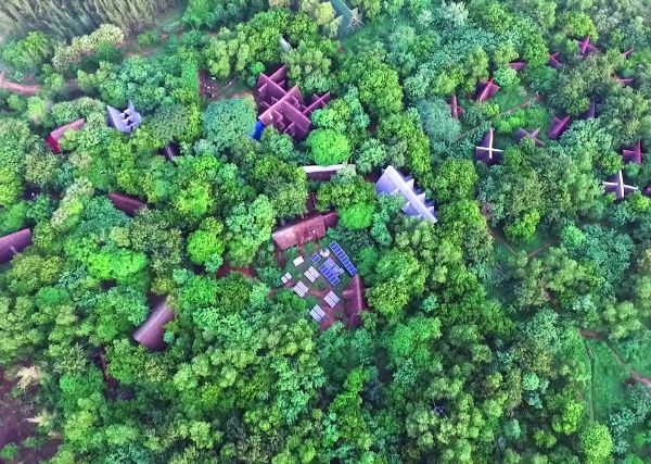 Aerial view of Sadhana Forest with eco-friendly structures among lush greenery.